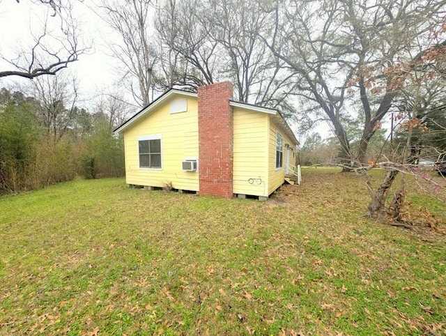 view of home's exterior with a chimney and a yard