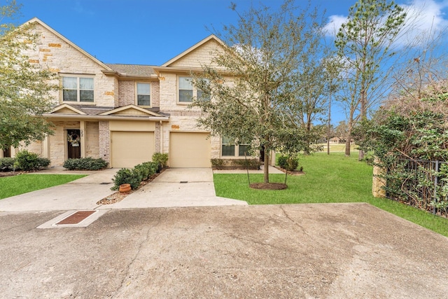 townhome / multi-family property featuring driveway, stone siding, a front yard, a garage, and brick siding