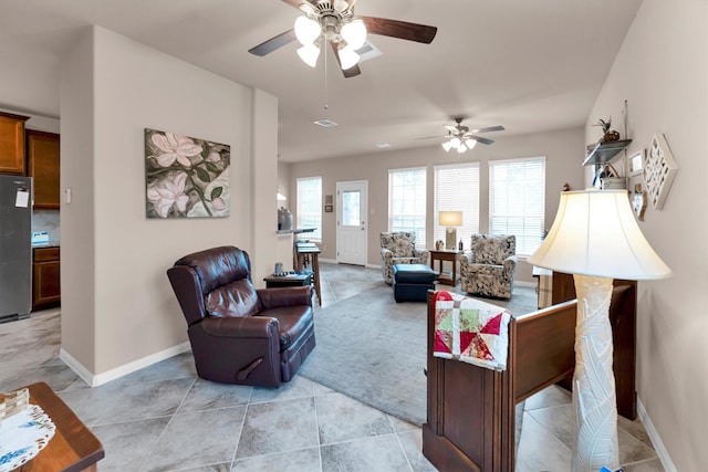 living area featuring light tile patterned flooring, visible vents, and baseboards