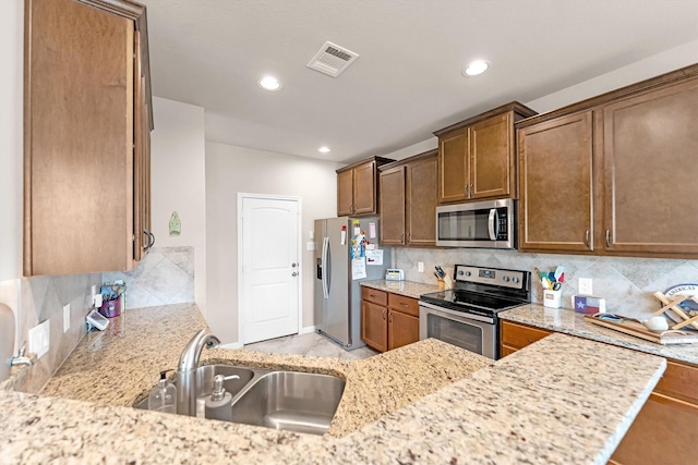 kitchen featuring a sink, stainless steel appliances, backsplash, and visible vents