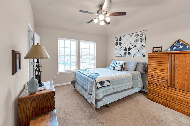 bedroom with light colored carpet, a ceiling fan, and baseboards