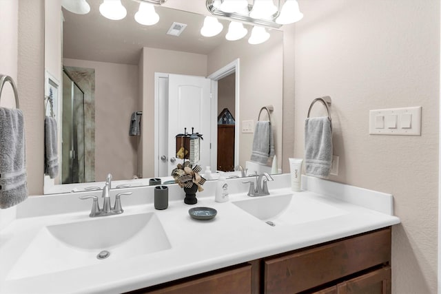 full bathroom with a sink, visible vents, a stall shower, and double vanity