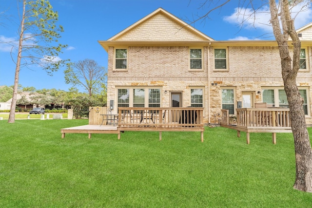 rear view of house featuring a yard, brick siding, and a deck