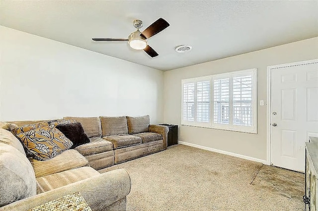 carpeted living area featuring baseboards, visible vents, and a ceiling fan