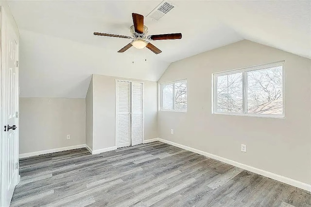 bonus room featuring baseboards, visible vents, a ceiling fan, lofted ceiling, and wood finished floors