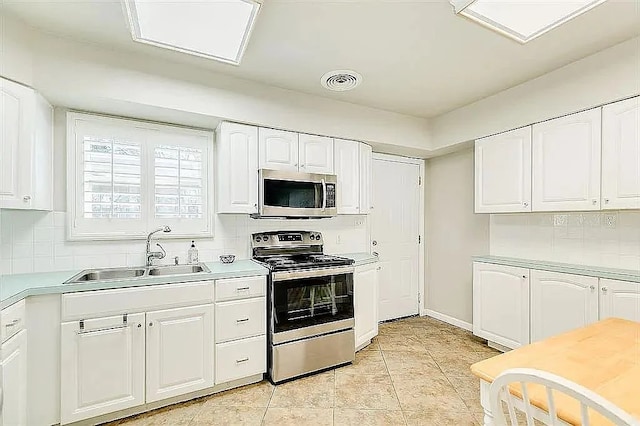 kitchen featuring a sink, white cabinetry, visible vents, appliances with stainless steel finishes, and tasteful backsplash