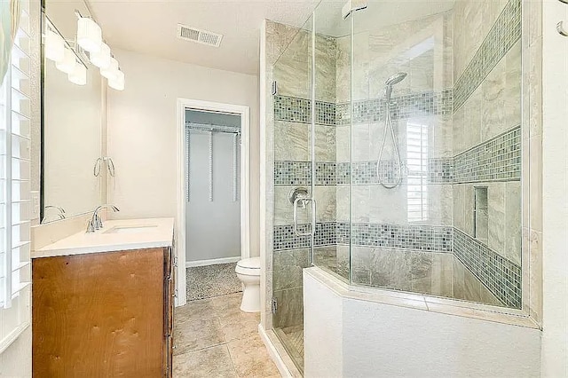 full bath featuring visible vents, toilet, a shower stall, vanity, and tile patterned flooring