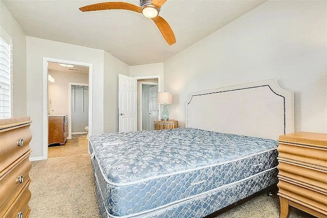 bedroom featuring ceiling fan, baseboards, a textured ceiling, and light colored carpet