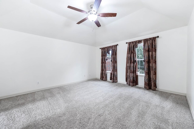 spare room with baseboards, vaulted ceiling, a ceiling fan, and light colored carpet