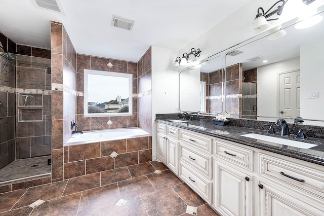 bathroom with a stall shower, visible vents, and a sink