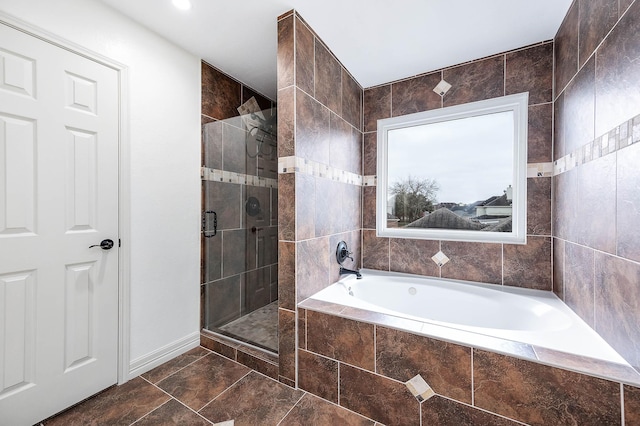 bathroom with a stall shower and a garden tub