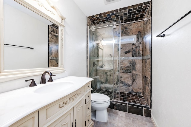 bathroom featuring toilet, a shower stall, and vanity