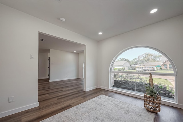 empty room featuring dark wood-type flooring, recessed lighting, visible vents, and baseboards