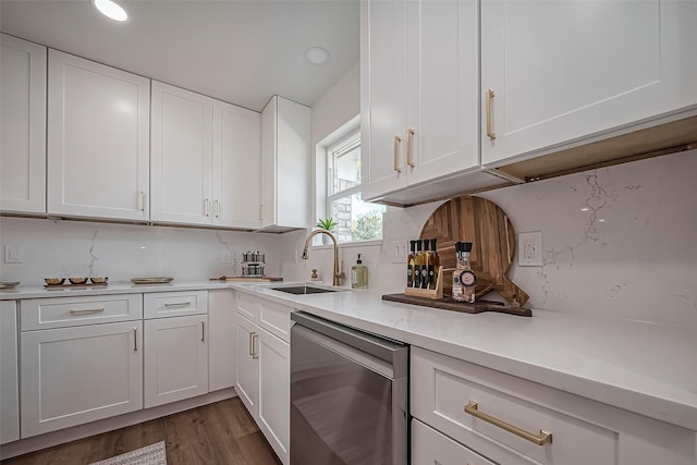 kitchen with light countertops, stainless steel dishwasher, dark wood-type flooring, white cabinets, and a sink