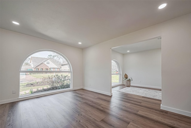 empty room featuring recessed lighting, baseboards, and wood finished floors