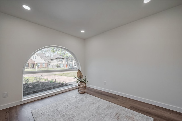 spare room with baseboards, wood finished floors, and recessed lighting