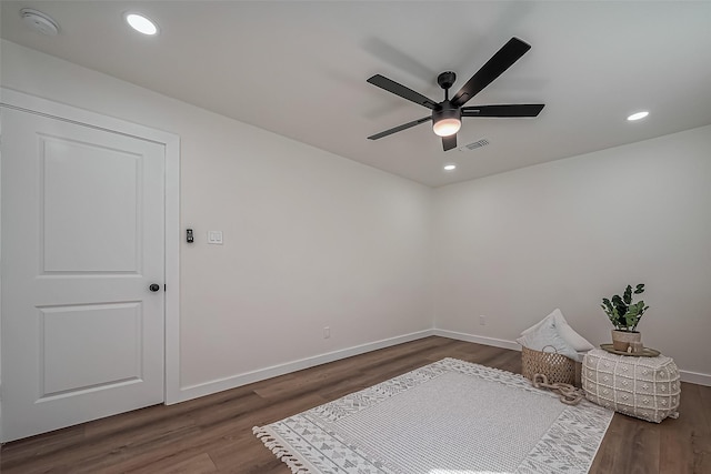 spare room with wood finished floors, visible vents, and baseboards