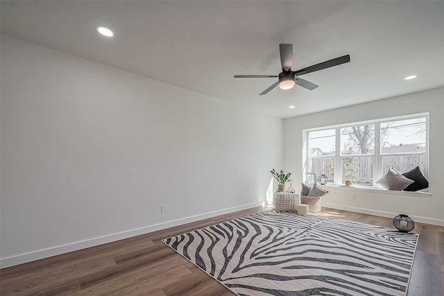 living area featuring baseboards, wood finished floors, and recessed lighting