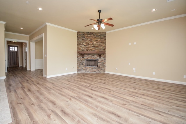 unfurnished living room featuring light wood-style flooring, crown molding, a stone fireplace, and baseboards