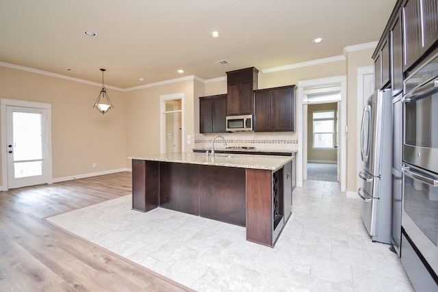 kitchen featuring appliances with stainless steel finishes, dark brown cabinets, backsplash, and ornamental molding