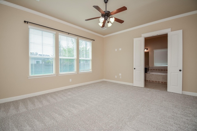 spare room featuring ceiling fan, baseboards, crown molding, and light colored carpet