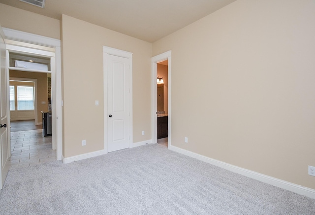 unfurnished bedroom featuring baseboards, visible vents, and light colored carpet