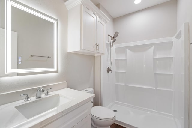 full bath with a stall shower, vanity, and toilet