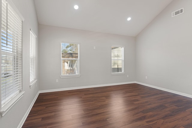 empty room with lofted ceiling, visible vents, recessed lighting, and wood finished floors