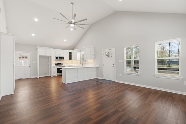 interior space with stainless steel appliances, light countertops, open floor plan, plenty of natural light, and a peninsula