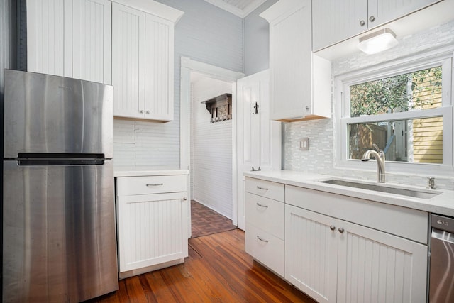 kitchen with stainless steel appliances, dark wood-style flooring, a sink, white cabinetry, and light countertops