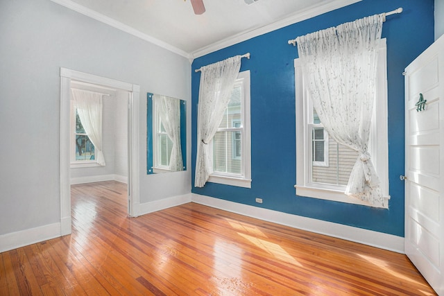 spare room with ceiling fan, crown molding, baseboards, and hardwood / wood-style flooring