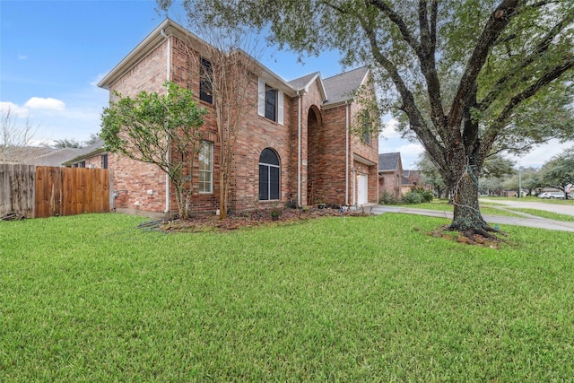 traditional-style house featuring concrete driveway, brick siding, and fence