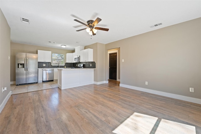 kitchen featuring visible vents, appliances with stainless steel finishes, white cabinetry, and open floor plan