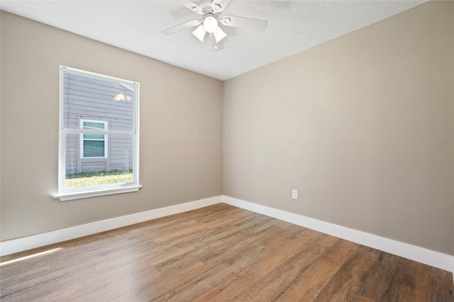 spare room with a ceiling fan, baseboards, and wood finished floors