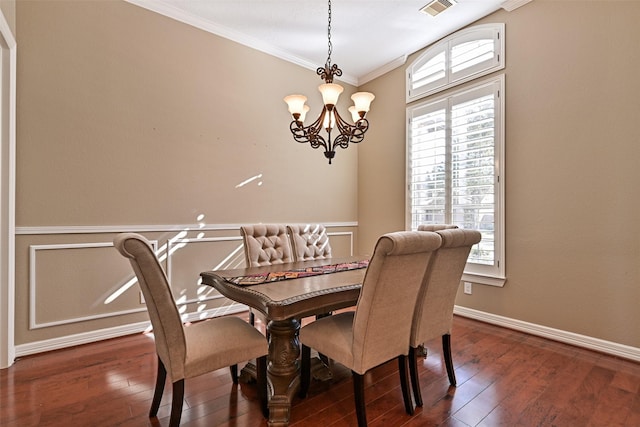 dining space with dark wood-style flooring, visible vents, crown molding, and an inviting chandelier