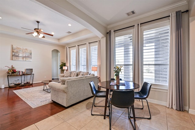 dining area featuring arched walkways, a wealth of natural light, and visible vents