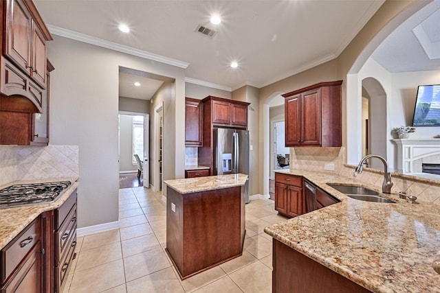 kitchen with stainless steel appliances, a center island, a sink, and baseboards