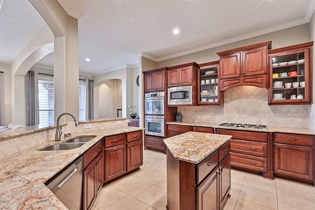 kitchen featuring light stone counters, light tile patterned floors, stainless steel appliances, backsplash, and a sink