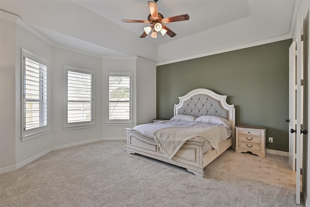 carpeted bedroom featuring ornamental molding, a raised ceiling, baseboards, and a ceiling fan