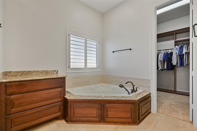 full bathroom with a garden tub, tile patterned flooring, and a spacious closet