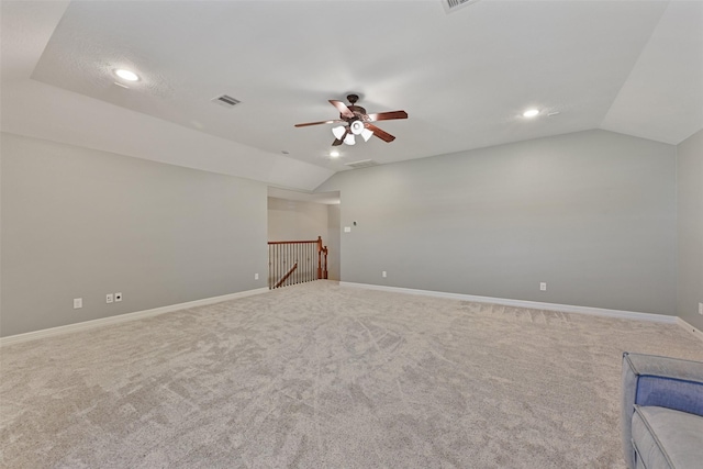 interior space featuring lofted ceiling, baseboards, visible vents, and carpet flooring