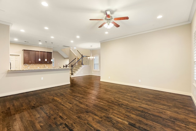 unfurnished living room with ornamental molding, dark wood finished floors, baseboards, and stairs