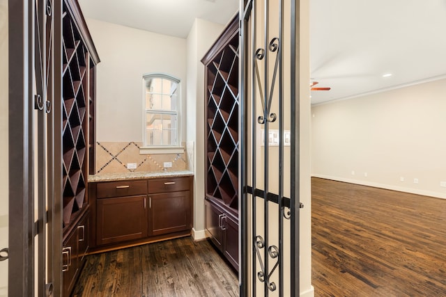 wine area with dark wood finished floors and baseboards