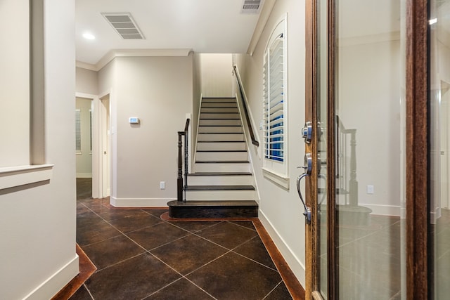 stairway featuring baseboards, visible vents, tile patterned flooring, and ornamental molding