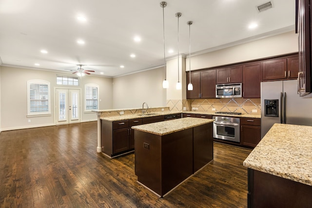 kitchen with stainless steel appliances, visible vents, crown molding, and a peninsula