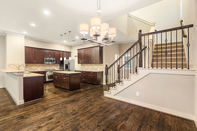 kitchen with dark wood finished floors, a kitchen island, ornamental molding, stainless steel appliances, and dark brown cabinets