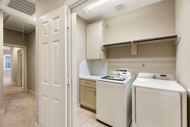 washroom featuring attic access, visible vents, cabinet space, and washer and clothes dryer