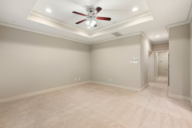 empty room featuring light carpet and a tray ceiling