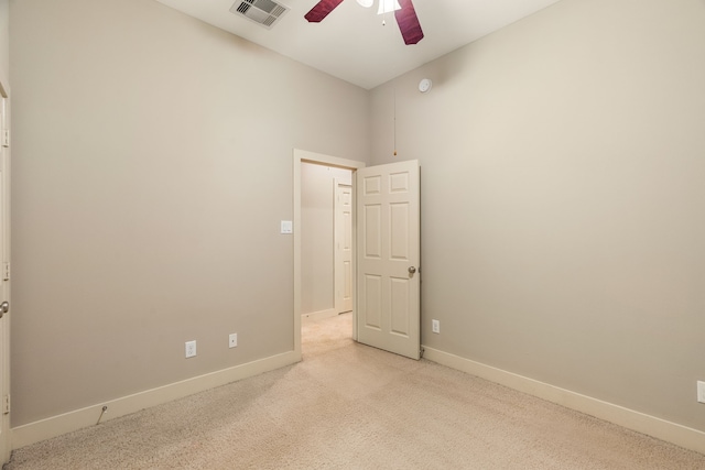 empty room with light carpet, baseboards, visible vents, and a ceiling fan