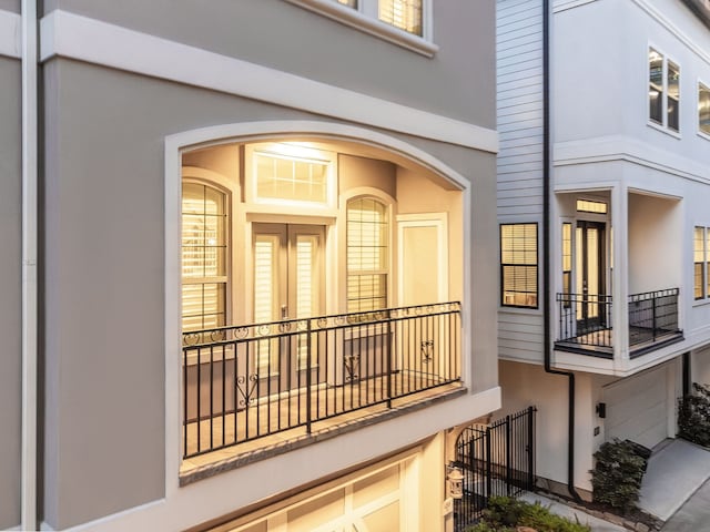 entrance to property with a balcony and stucco siding